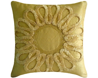 May include: A square throw pillow in a solid golden yellow color. The center features a circular design surrounded by a ring of twelve petal-like loops made from gathered fabric ribbon, creating a textured, raised floral pattern on the front.