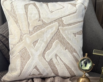May include: A square throw pillow featuring a textured beige background with an abstract, raised white velvet pattern. The design consists of large, flowing, organic shapes that create a layered effect across the entire front surface of the pillow.