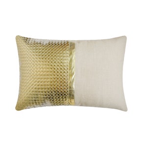 Peut inclure: Un coussin rectangulaire avec une housse en tissu de lin beige. Un côté du coussin présente un tissu matelassé doré avec une bordure en cuir doré.