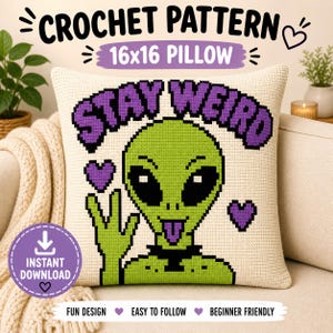Puede incluir: Una almohada de crochet color crema con un diseño de alienígena verde y las palabras "STAY WEIRD" en morado. La almohada está etiquetada como "16x16 PILLOW" e incluye el texto "INSTANT DOWNLOAD". El diseño también incluye corazones morados y las palabras "FUN DESIGN", "EASY TO FOLLOW" y "BEGINNER FRIENDLY".