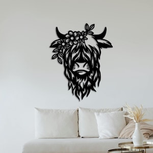 May include: Black silhouette of a Highland cow head with floral accents. The cow's face is detailed with a fluffy mane and a nose.
