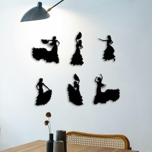 Peut inclure: Six autocollants muraux en silhouette noire de femmes en robes de flamenco. Les femmes sont dans différentes poses, certaines tenant des éventails, d'autres avec les bras tendus.