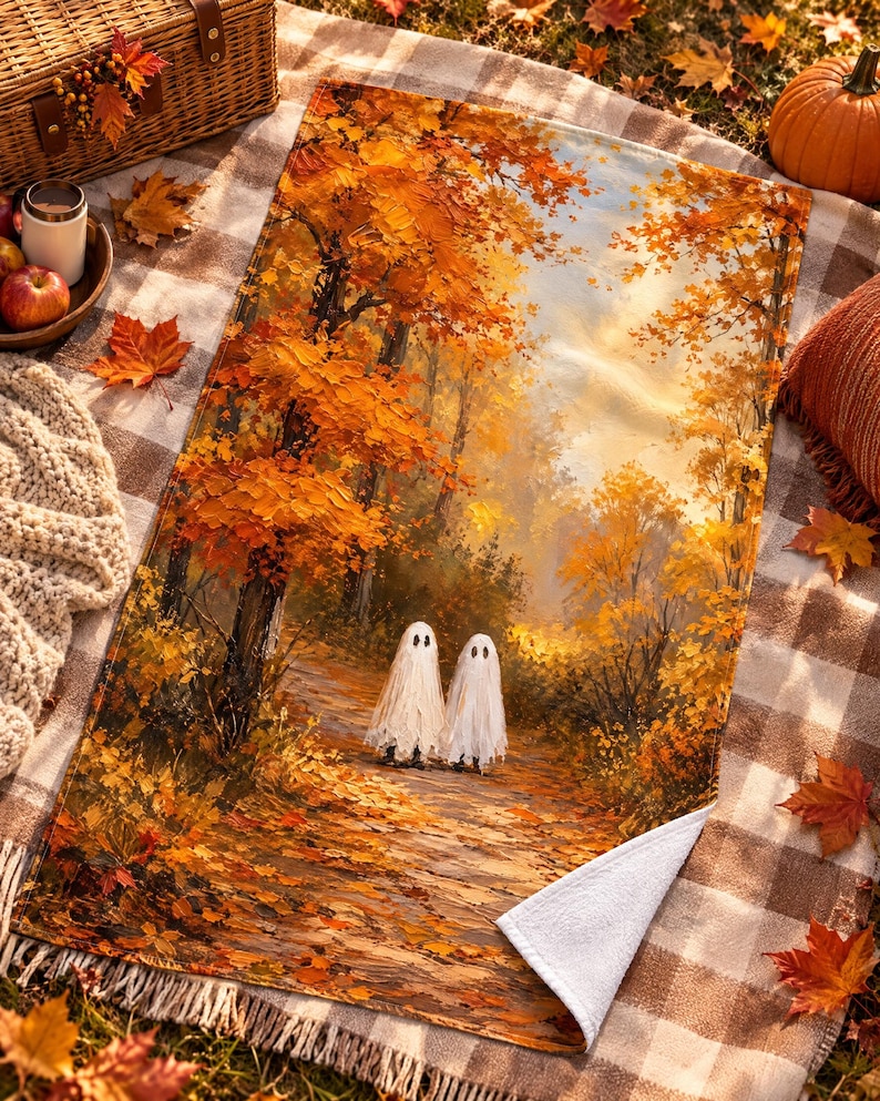 Pu&ograve; includere: Una coperta rettangolare con una stampa in stile pittura a olio raffigurante due fantasmi bianchi su un sentiero in un bosco pieno di vivaci foglie autunnali arancioni e gialle. La coperta ha un lato inferiore bianco e un angolo ripiegato.