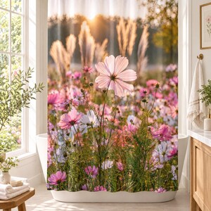 K&ouml;nnte beinhalten: Ein Duschvorhang mit einem Fotodruck eines Feldes aus rosa und wei&szlig;en Kosmosblumen unter einem goldenen Sonnenuntergangshimmel. Das Design zeigt hohe Gr&auml;ser im Hintergrund und gr&uuml;ne St&auml;ngel in der gesamten Blumenwiese.