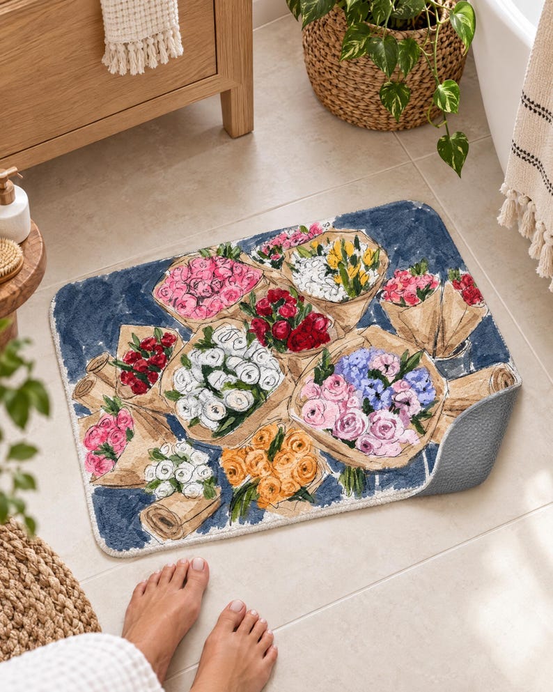 K&ouml;nnte beinhalten: Eine rechteckige Badematte mit dunkelblauem Hintergrund und einem Aquarell-Druck von mehreren Blumenstr&auml;u&szlig;en, die in braunes Papier eingewickelt sind. Die Blumenarrangements zeigen rosa, wei&szlig;e, rote, gelbe, orangefarbene und violette Bl&uuml;ten.