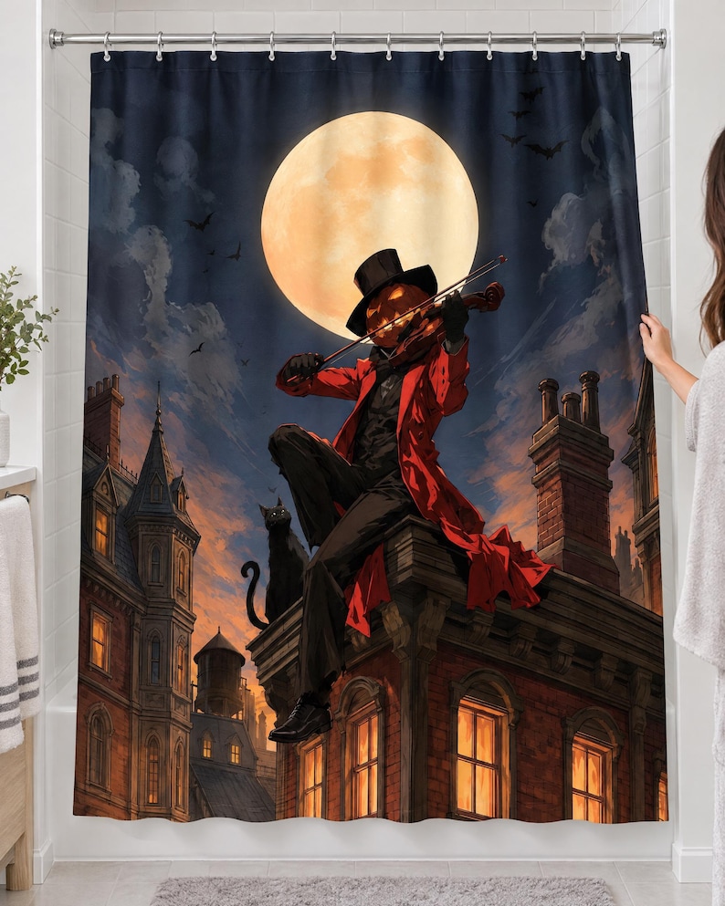 Pumpkin violinist full moon shower curtain over a bathtub in a white-tiled bathroom: a pumpkin-headed figure in a top hat and red coat plays violin on a brick rooftop beside a black cat; a woman's hand pulls back the right edge.
