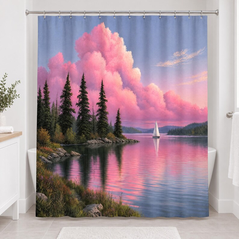 Straight-on view of the whole pine lake sailboat shower curtain hanging in a white bathroom, showing the grassy rocky shore, pines, white sailboat, pink clouds and their reflection in the water.