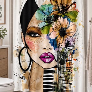 May include: A white shower curtain featuring a large, artistic illustration of a person's face with vibrant watercolor flowers in shades of orange, green, and blue, bright pink lips, a black hoop earring, and black and white striped accents.