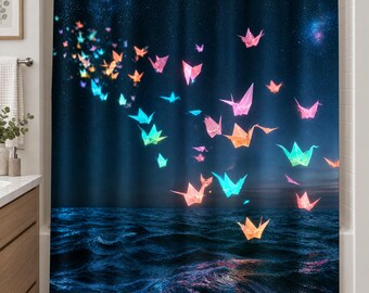 Peut inclure: Un rideau de douche représentant un ciel nocturne bleu foncé parsemé d'étoiles au-dessus d'un océan bleu profond. De nombreuses grues en origami lumineuses aux teintes vives de rose, orange, jaune et turquoise semblent voler au-dessus.