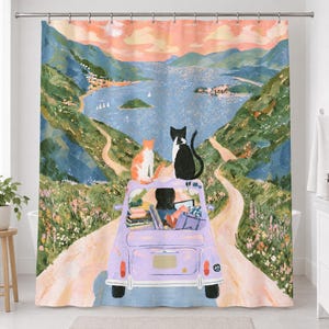 Straight-on view of the whole lavender car cats shower curtain hanging in a white bathroom, showing the pink sky, blue bay with small islands, winding road, the dark-haired driver, luggage and two cats on the car.
