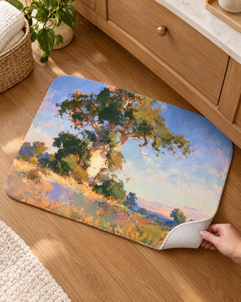 May include: A rectangular floor mat featuring an impressionistic landscape painting of a large tree standing in a grassy field under a bright blue sky. The artwork uses visible brushstrokes in shades of green, yellow, orange, and blue.