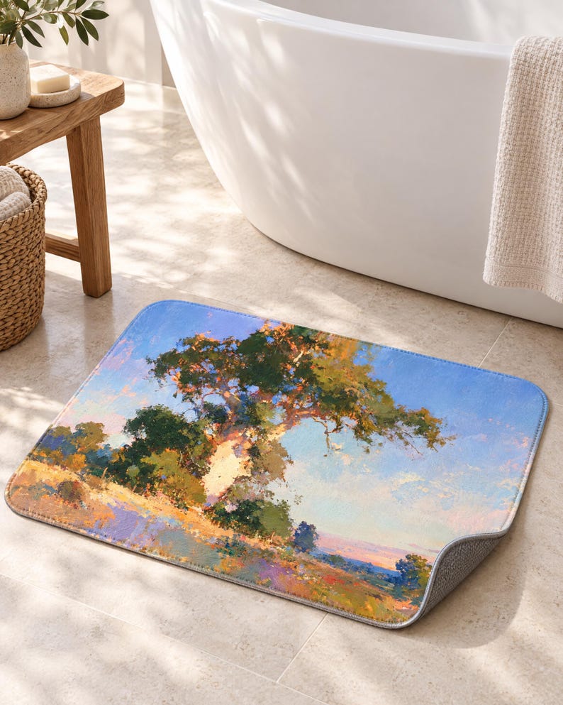 May include: A rectangular bath mat featuring an impressionistic landscape painting of a large tree with green foliage set against a light blue sky. The ground is depicted with textured brushstrokes in shades of yellow, orange, and purple.