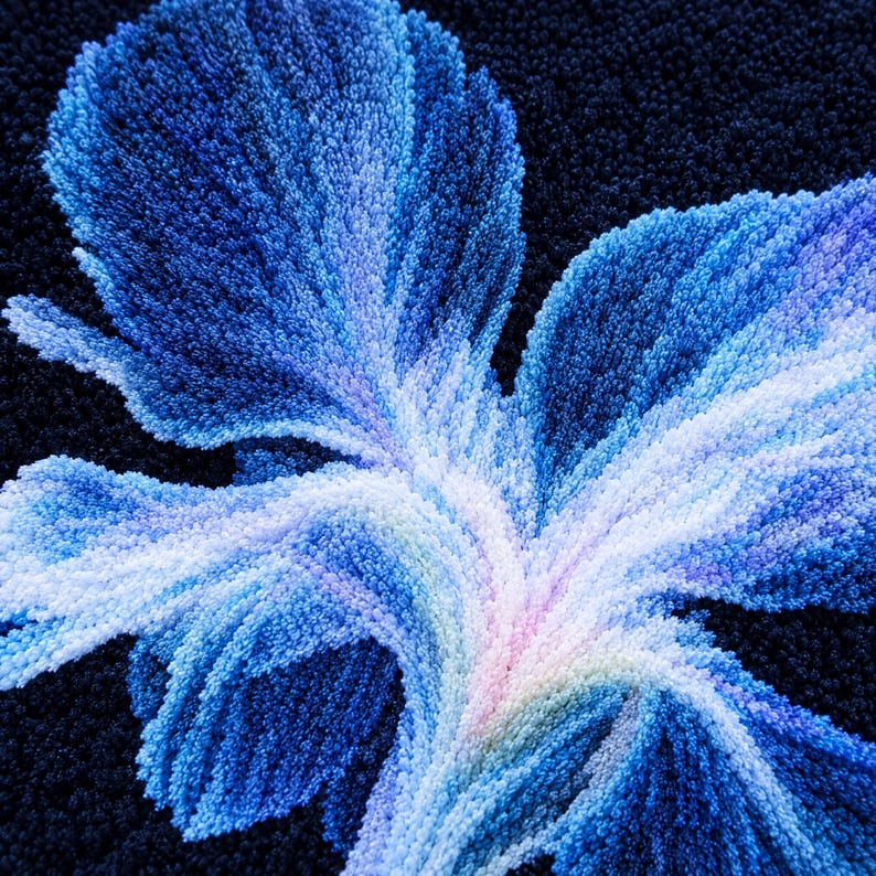 May include: A tufted textile piece featuring a large, stylised floral motif in shades of deep navy, royal blue, light blue, and white. The design is created with dense, textured yarn loops set against a solid, dark navy blue background.