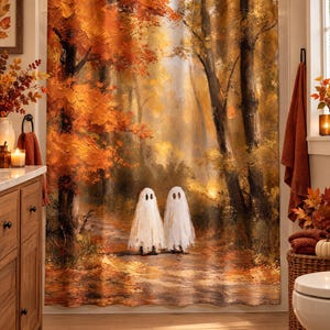 Puede incluir: Una cortina de ducha con una escena de bosque al estilo de pintura al &oacute;leo con vibrantes hojas de oto&ntilde;o naranjas y amarillas en los &aacute;rboles. Dos peque&ntilde;as figuras de fantasmas blancos con ojos negros se sit&uacute;an en un sendero.