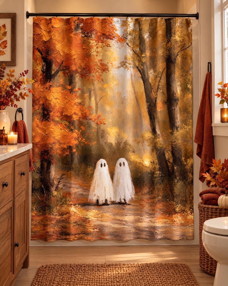 Puede incluir: Una cortina de ducha con una escena de bosque al estilo de pintura al &oacute;leo con vibrantes hojas de oto&ntilde;o naranjas y amarillas en los &aacute;rboles. Dos peque&ntilde;as figuras de fantasmas blancos con ojos negros se sit&uacute;an en un sendero.