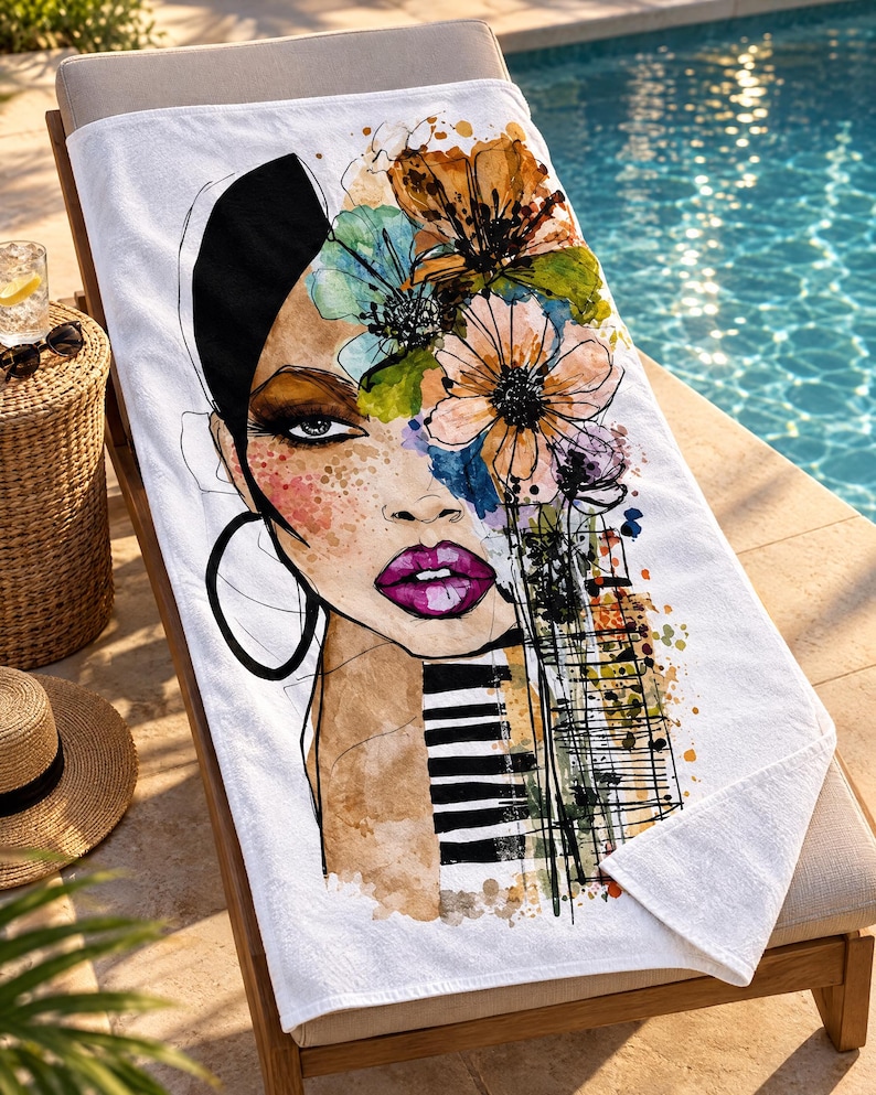 May include: A white beach towel featuring a colorful watercolor-style illustration of a face with vibrant purple lips, large hoop earrings, and a head of flowers. The design includes black and white piano keys and abstract paint splatters.