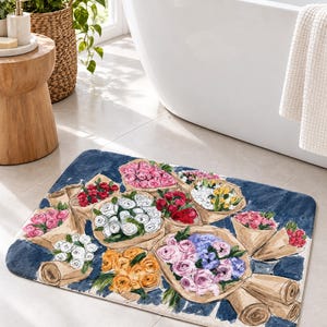 K&ouml;nnte beinhalten: Eine rechteckige Badematte mit einem Aquarell-Druck von mehreren in braunes Papier eingewickelten Blumenstr&auml;u&szlig;en auf dunkelblauem Hintergrund. Die Str&auml;u&szlig;e bestehen aus verschiedenen Farben wie rosa, wei&szlig;en, roten, gelben und violetten Rosen.