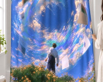 Può includere: Una tenda da doccia con una stampa surreale di una persona in piedi in un campo di fiori selvatici gialli e blu, che guarda verso un cielo blu vorticoso pieno di nuvole bianche e fogli rettangolari che fluttuano nell'aria.