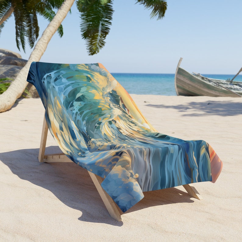 Ocean wave beach towel draped over a wooden beach chair on white sand, the print a swirling blue and teal wave with golden sunset light, palm trees and a turquoise sea behind.