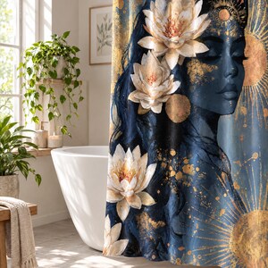 Puede incluir: Una cortina de ducha con fondo azul oscuro y una ilustraci&oacute;n de perfil de un rostro adornado con flores de loto blancas. El dise&ntilde;o incluye patrones de rayos de sol dorados y salpicaduras de pintura dorada sobre la tela.