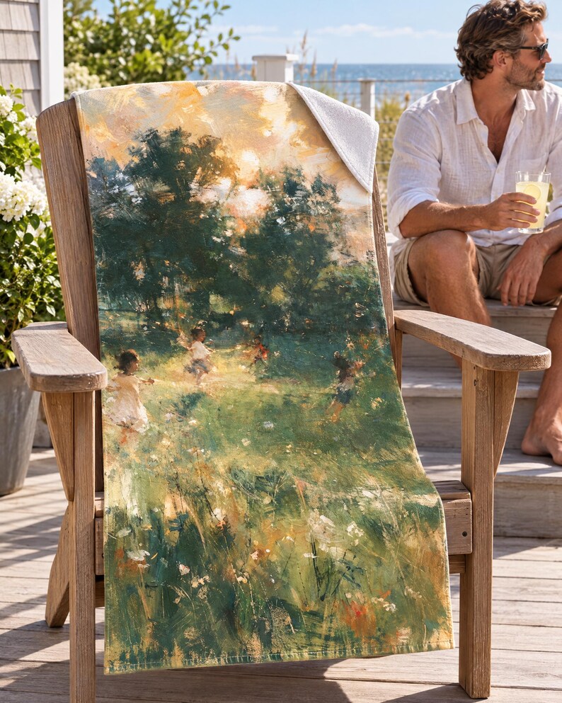 Impressionist garden beach towel draped over a wooden Adirondack chair on a seaside deck, a top corner folded back to the white terry back; a man in sunglasses and a white linen shirt sits nearby holding a drink.