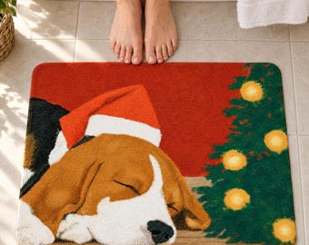 Peut inclure: Un tapis de bain rectangulaire représentant un chien beagle endormi portant un bonnet de Père Noël rouge et blanc. Le fond est d'un rouge uni avec un sapin de Noël vert décoré d'ornements circulaires jaunes sur le côté droit du tapis.