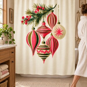 Wider view of a sunny bathroom with the vintage ornament shower curtain closed across the tub, a wooden vanity and plant to the left and a woman in a white robe walking past barefoot.