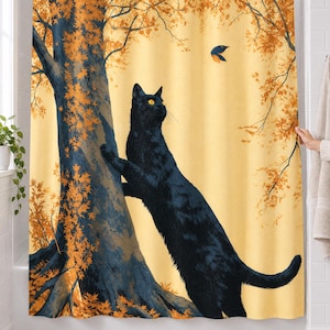 Autumn tree cat shower curtain over a bathtub in a white-tiled bathroom: a cat reaches up a big tree trunk toward a small bird among orange leaves, its body running down to the bottom hem; a hand pulls back the right edge.