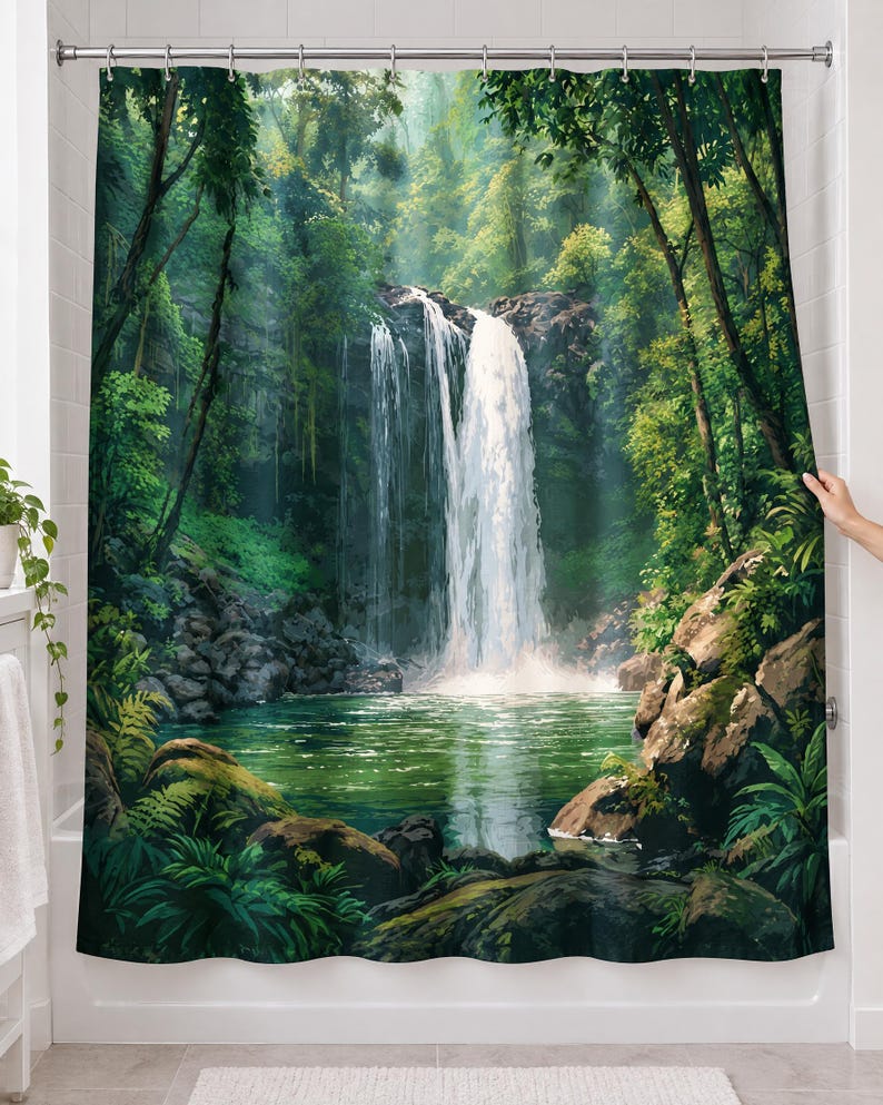 Rainforest waterfall shower curtain over a bathtub in a white-tiled bathroom: a tall waterfall spills into a green pool between mossy boulders, ferns and jungle trees; a hand pulls back the right edge.