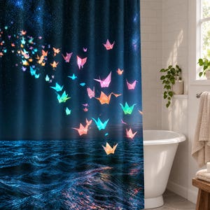 Pu&ograve; includere: Una tenda da doccia che raffigura un cielo notturno blu scuro pieno di stelle sopra un oceano blu profondo. Numerose gru origami luminose e multicolori, nelle tonalit&agrave; del rosa, arancione, giallo e turchese, sono sparse sulla scena, sembrando volare dal cielo verso la superficie dell'acqua.