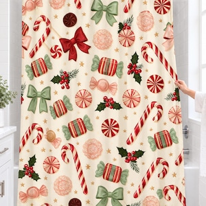 Candy cane Christmas shower curtain with candy canes, peppermint swirls, striped candies, bows and holly on cream, hanging on a chrome rod in a white bathroom.