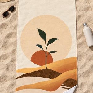 Top-down view of the whole boho sun seedling beach towel laid flat on sand, with plain cream space above the sun and a second small soil mound at the right, plus a straw hat, sunglasses and a white water bottle.