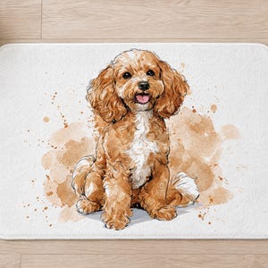 Overhead view of the whole Cavapoo puppy bath mat on a light wood floor, with rolled white towels, a lit candle and a potted plant beside it.