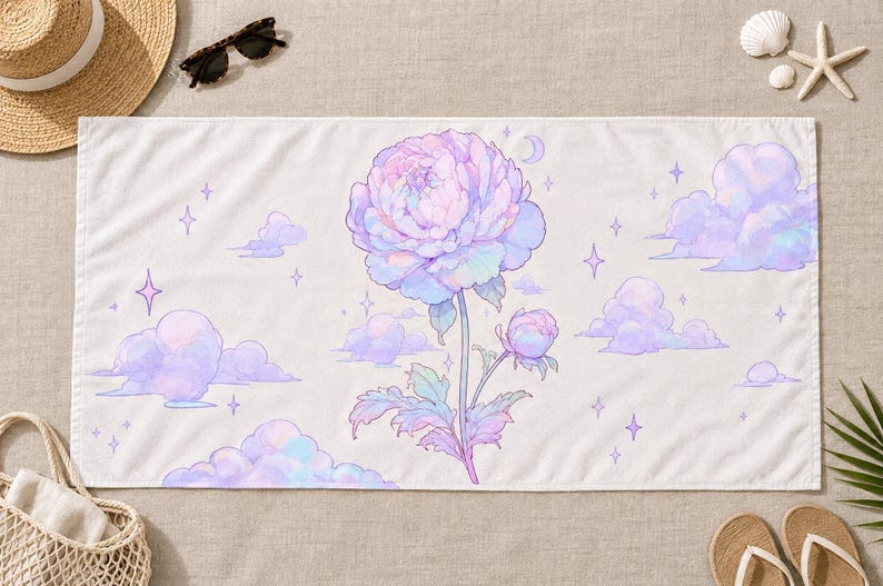 May include: A rectangular beach towel featuring a central large, pastel-colored peony flower with a smaller bud on a stem. The background is white with scattered light purple clouds, small four-pointed stars, and a crescent moon illustration.