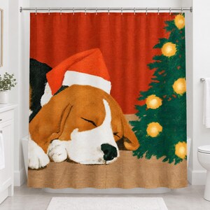 Straight-on front view of the sleeping beagle Santa hat shower curtain hanging from a chrome rod over a white tub.