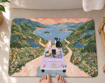 Può includere: Un tappetino da bagno rettangolare con una colorata illustrazione di un'auto color viola chiaro che percorre una strada sterrata verso un paesaggio costiero. Due gatti sono seduti sul tetto dell'auto, mentre all'interno si vedono libri e un computer portatile. La scena include colline verdi, fiori selvatici e un mare blu sotto un cielo al tramonto.