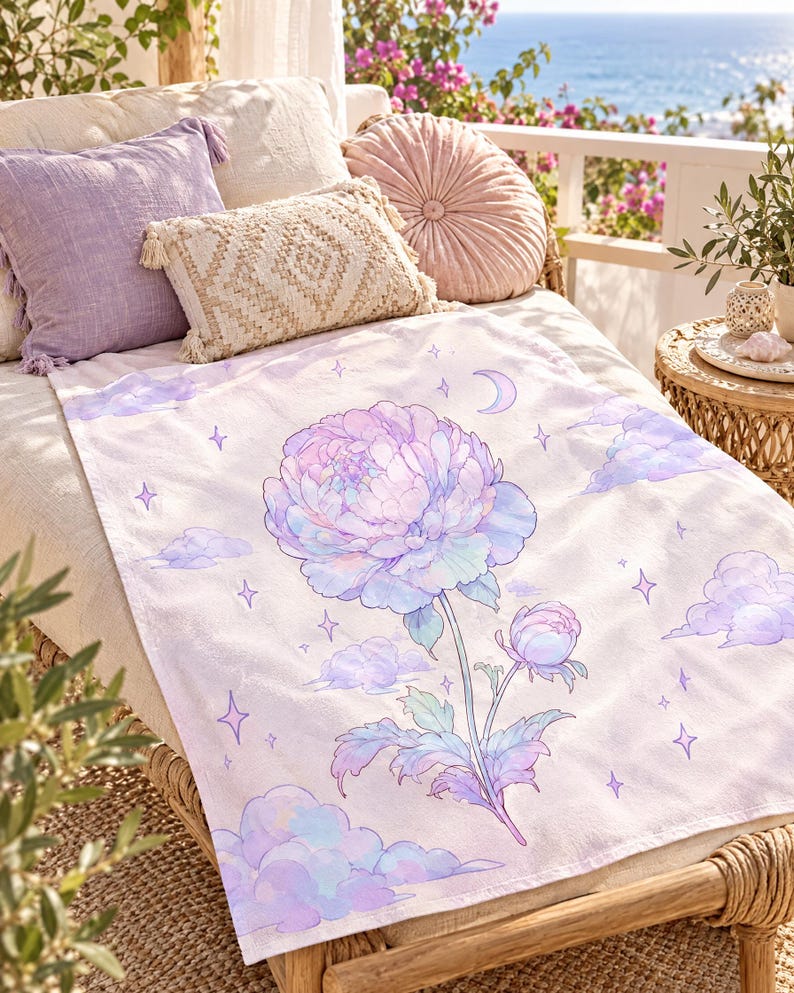 May include: A rectangular throw blanket featuring a large, central pastel-colored peony flower illustration. The design includes soft purple and blue clouds, small four-pointed stars, and a crescent moon against a light, off-white background.