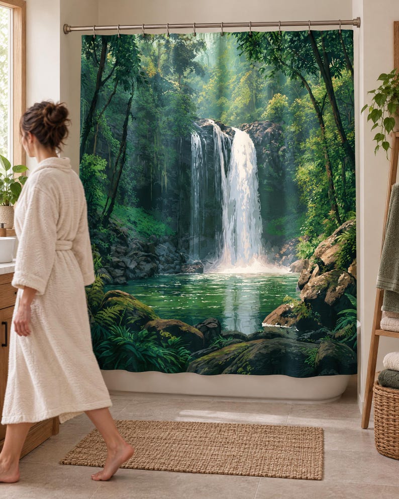 Wider view of a bright bathroom with the rainforest waterfall shower curtain closed across the tub and a woman in a white robe walking past barefoot on a woven rug, partly hiding the left side of the design.