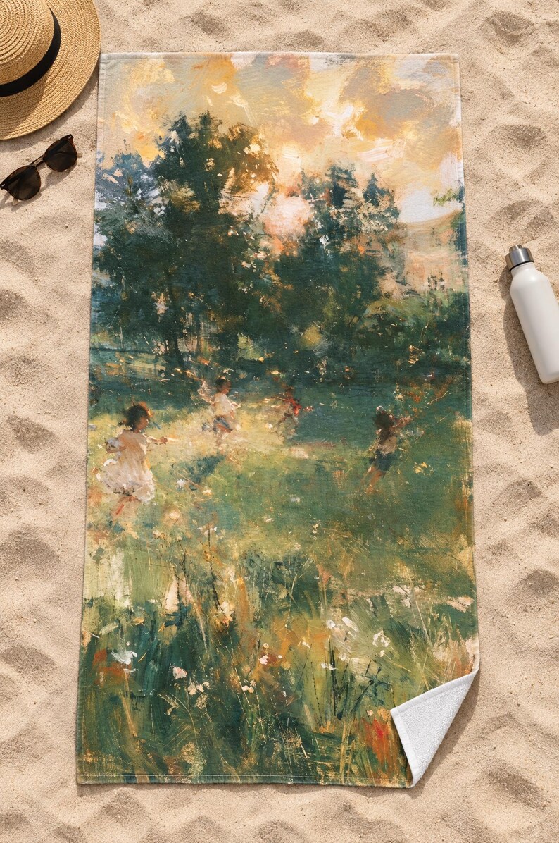 Top-down view of the whole impressionist garden beach towel laid flat on sand, showing the children in the meadow and the tall grass below, with a straw hat, sunglasses and a white water bottle; one corner folds back.