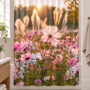 K&ouml;nnte beinhalten: Ein Duschvorhang mit einem Fotodruck eines Feldes voller bl&uuml;hender rosa und wei&szlig;er Kosmeen. Die Szene wird von warmem, goldenem Sonnenlicht beleuchtet, das durch hohe Gr&auml;ser im Hintergrund f&auml;llt und eine sanfte, leuchtende Atmosph&auml;re schafft.