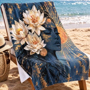 K&ouml;nnte beinhalten: Ein rechteckiges Strandtuch mit dunkelblauem Hintergrund und goldenen Farbspritzern. Das Design zeigt das Profil eines Gesichts mit geschlossenen Augen, drei gro&szlig;e wei&szlig;e Lotusbl&uuml;ten und ein goldenes Sonnenmotiv mit strahlenden Strahlen.
