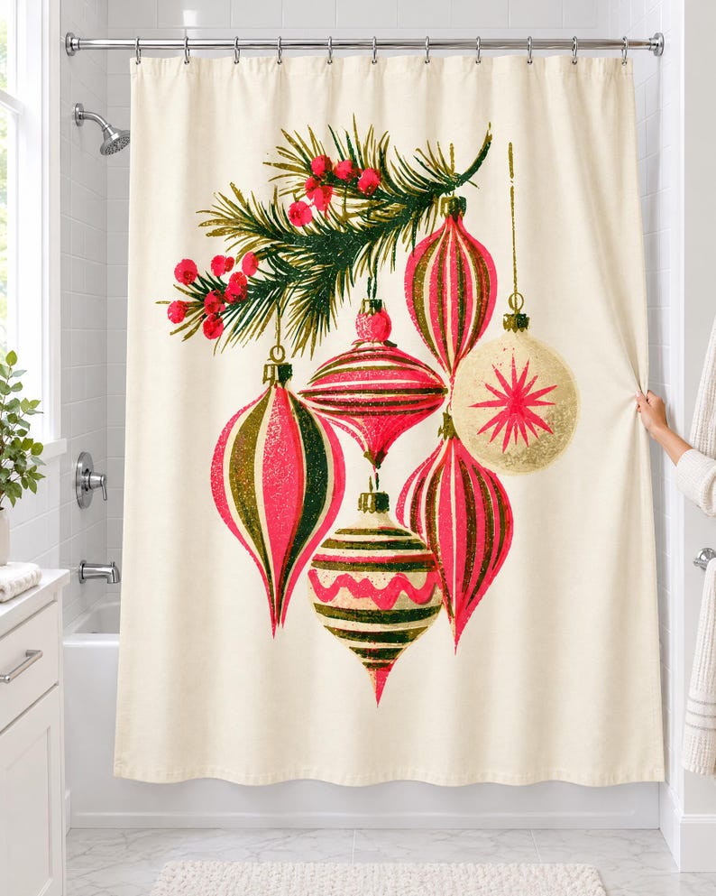 Vintage ornament shower curtain hanging over a bathtub in a white-tiled bathroom: six large striped pink, olive and cream Christmas baubles hang from a pine sprig with red berries; a hand pulls back the right edge.