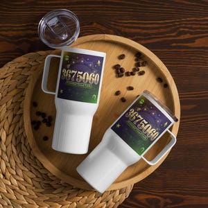 Peut inclure: Deux tasses de voyage blanches avec un motif noir, vert et or. Le motif présente le numéro 3675060 et les mots "Extreme Good Luck".