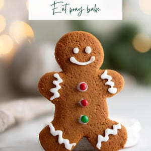 Könnte beinhalten: Ein Lebkuchenmann-Keks mit weißen Zuckergussdetails und bunten Bonbonknöpfen. Der Keks hat ein lächelndes Gesicht und ist mit weißen Zuckerguss-Zickzacklinien verziert. Der Text oben lautet "EASY CHRISTMAS BAKING" und "Eat pray bake".