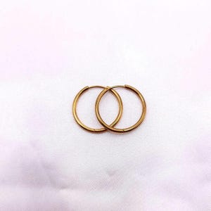 May include: A pair of gold hoop earrings. The earrings are simple and elegant, and they would be a great addition to any jewelry collection.