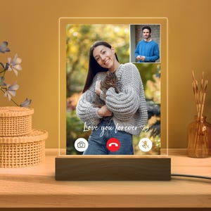 Könnte beinhalten: Ein personalisiertes LED-Nachtlicht mit einem Foto einer Frau, die eine Katze hält, und einem kleineren Foto eines Mannes. Die Worte "Love you forever" sind auf dem Licht geschrieben. Das Licht steht auf einem Holzsockel.
