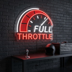 May include: A neon sign with a speedometer design, featuring the words "FULL THROTTLE" in white and red. The sign is mounted on a black brick wall. A black helmet, toolbox, and gear shift are on a black table.