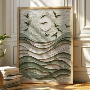 Peut inclure: Une œuvre d'art encadrée représentant un soleil et des oiseaux volant au-dessus de collines ondulées, réalisée en papier superposé. L'œuvre a un cadre en bois naturel et une palette de couleurs blanche, verte et beige. Un pot de plante et des livres sont au premier plan.