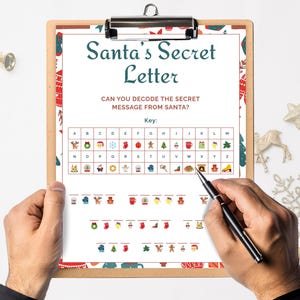May include: A clipboard holds a Christmas-themed activity sheet titled "Santa's Secret Letter." The sheet features a key for decoding a secret message, with festive icons. A hand holds a pen, ready to solve the puzzle. The background is white with Christmas ornaments.