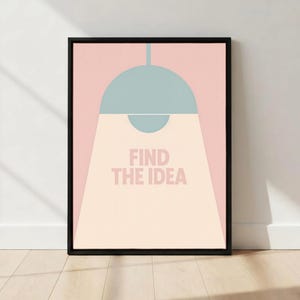 May include: A framed art print featuring a stylized illustration of a light fixture. The design includes a light blue lamp against a pink background, with the words "FIND THE IDEA" in the center. The frame is black.